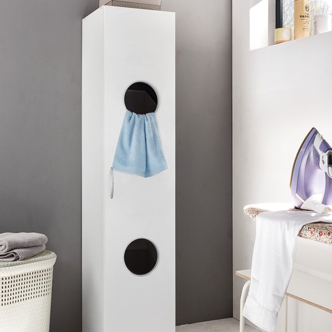Colonne étroite glissée entre le mur et le panier à linge d’une salle de bain
