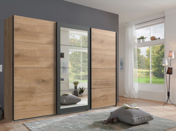 Penderie à portes coulissantes en bois clair face au couchage