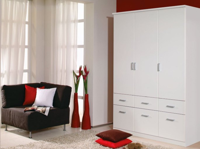 Meuble de rangement blanc à portes battantes ouvertes dans un coin de chambre
