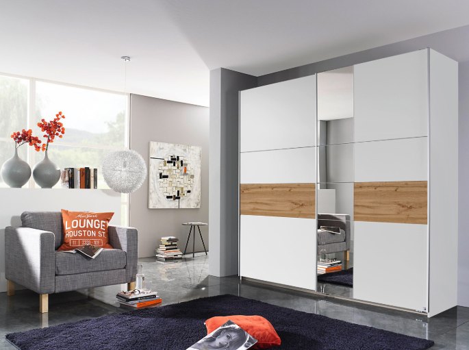 Façade coulissante à panneaux miroir et bandeau bois dans une chambre claire