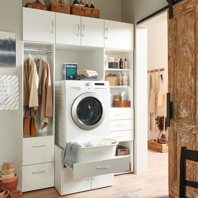 Coin lessive aménagé dans un dégagement, avec lave-linge encastré et tablettes hautes