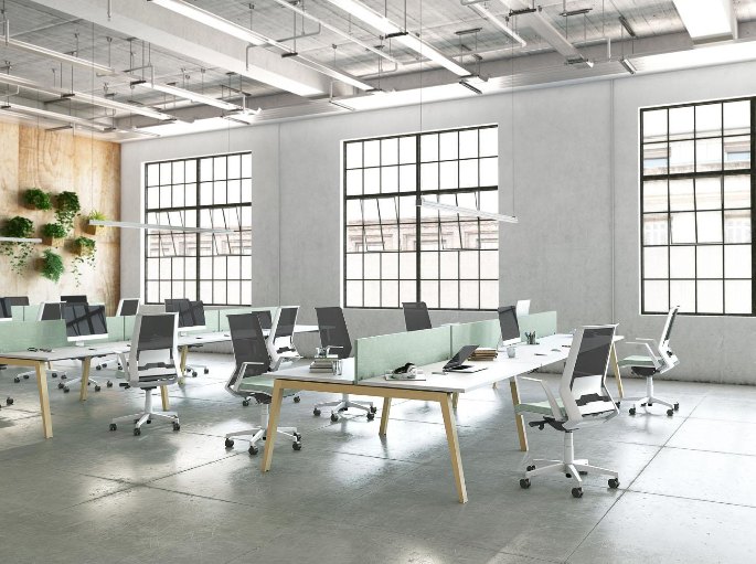 Plateau partagé en open space avec postes non attribués devant de grandes fenêtres