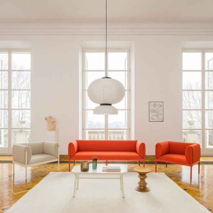 Pièce de détente très éclairée par de hautes fenêtres, avec banquette basse et guéridon