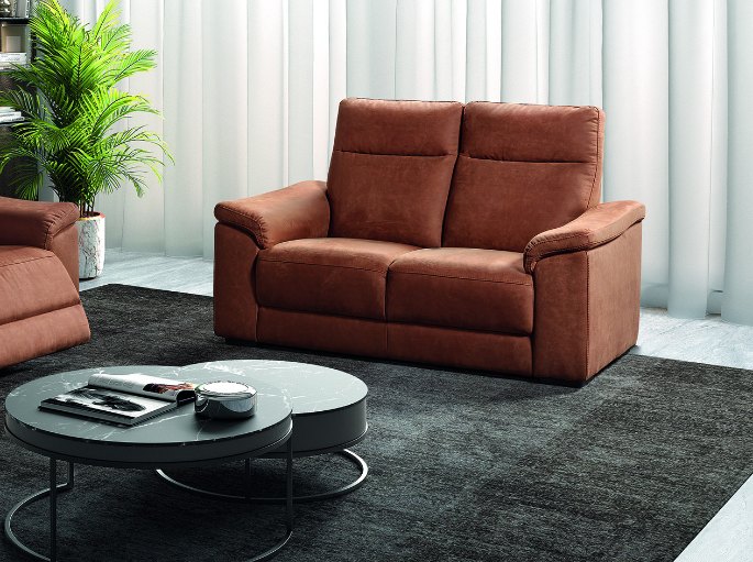 Séjour clair avec un deux places en tissu terracotta et un tapis gris
