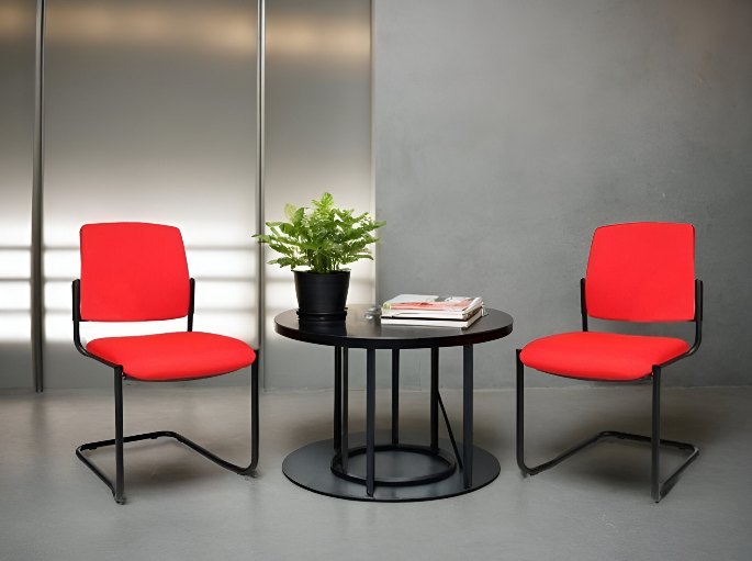Deux fauteuils rouges de part et d'autre d'un guéridon dans un coin d'attente sombre