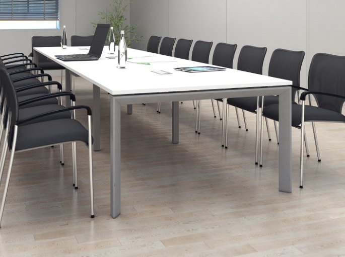 Longue table blanche de conseil bordée de sièges noirs à piètement luge