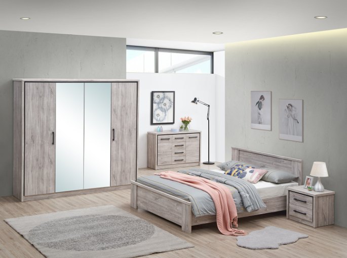 Empilement de coussins de tête devant un panneau de lit en bois