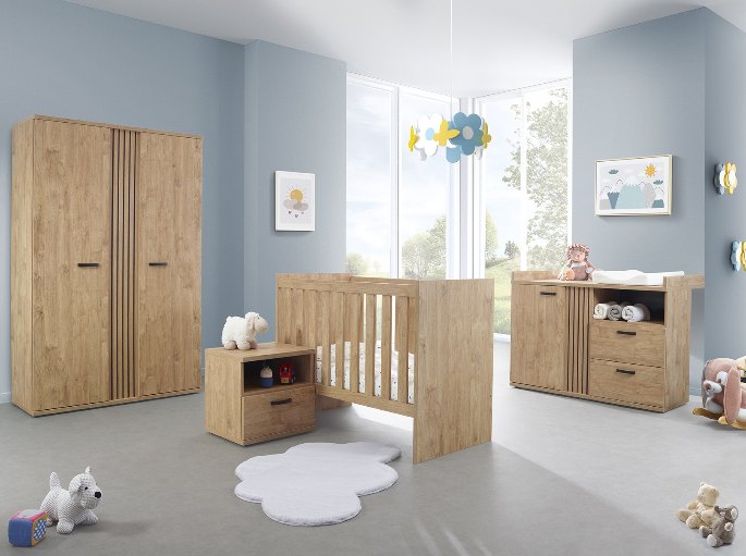 Mobilier de chambre de bébé coordonné en bois clair autour d'un couchage à barreaux
