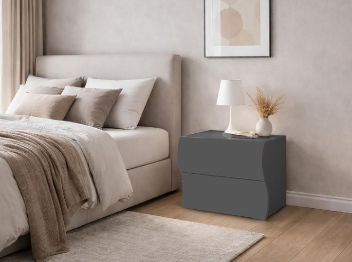 Table de nuit à deux tiroirs installée contre un lit tapissier, plateau au niveau du matelas