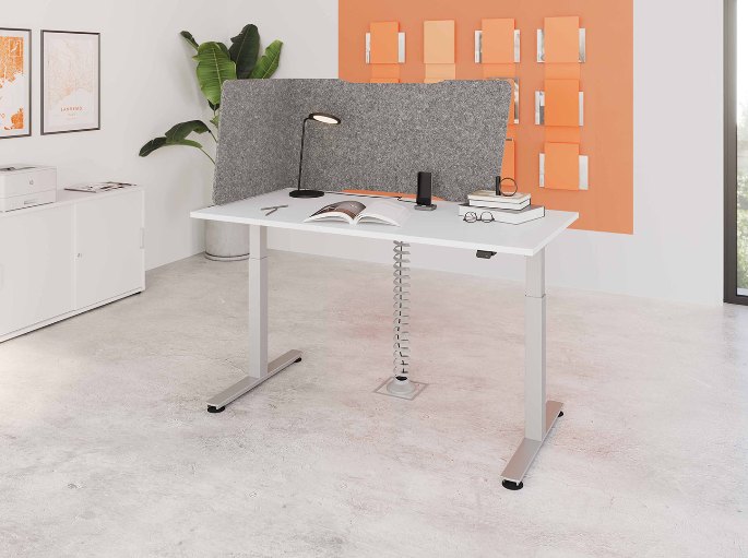Poste de travail devant un mur orange saturé et une paroi grise en feutre