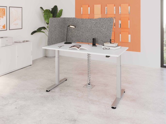 Écran d'angle en feutre gris fixé sur un bureau réglable dans un bureau lumineux
