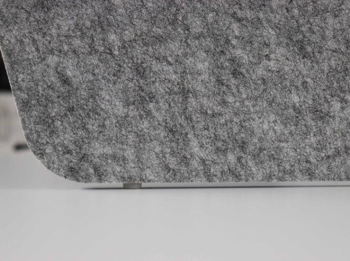 Gros plan sur un feutre de polyester gris aux fibres apparentes, matériau poreux qui absorbe le son
