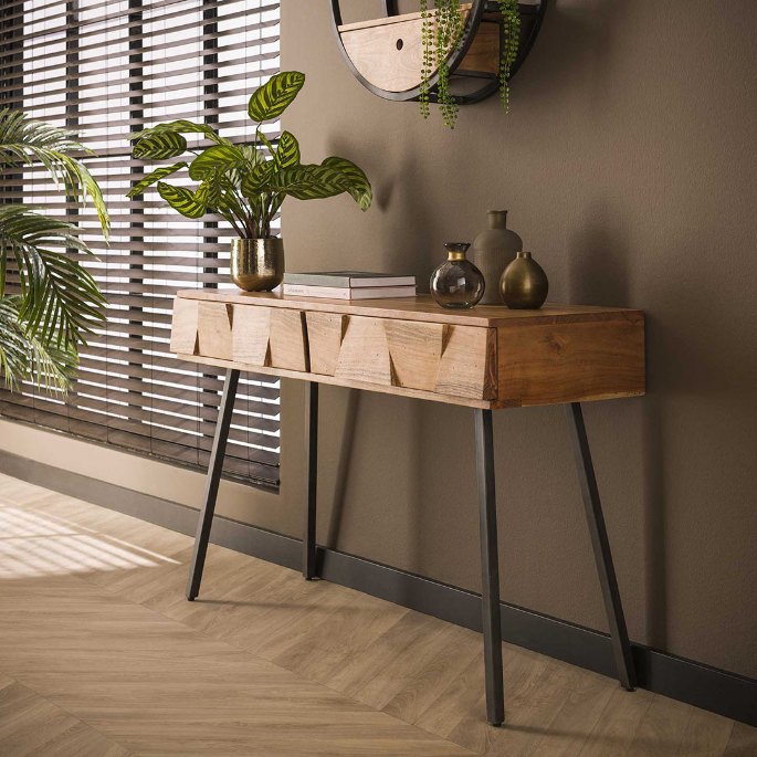 Plateau en acacia à tiroirs avec vases en laiton et plante devant une fenêtre à stores