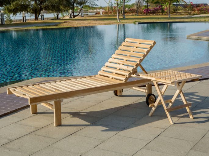 Couchage plat en lattes de bois installé face à l’eau pour une pause au soleil