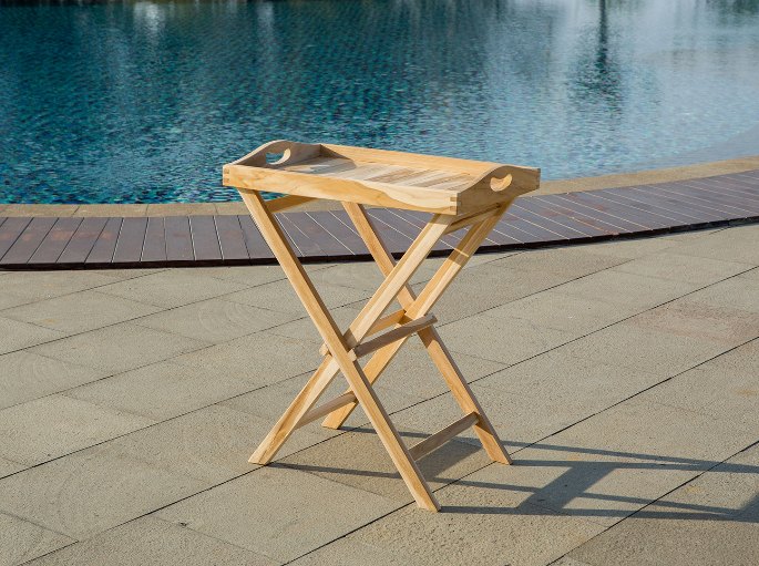 Guéridon pliant en lattes servant de plan d’appoint sur une terrasse au bord d’un bassin