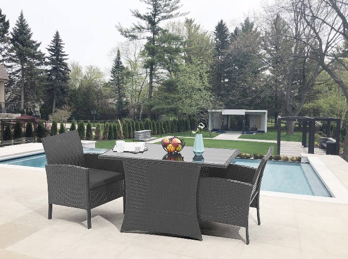 Mobilier d'extérieur sombre en fibre tressée installé au bord d'une piscine