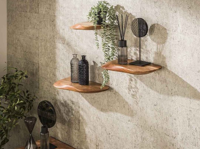 Trois tablettes en acacia massif installées en décalé sur un mur en béton clair