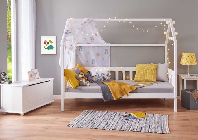Couchage bas en pin laqué installé dans une chambre de petit garçon