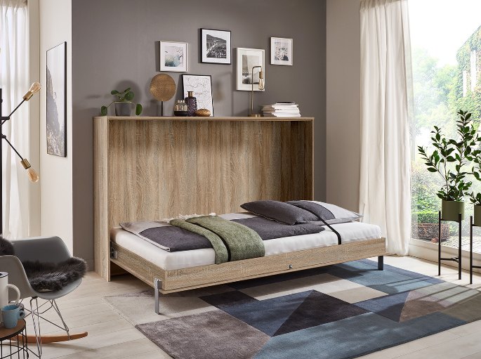 Couchage déplié devant la fenêtre dans un logement compact