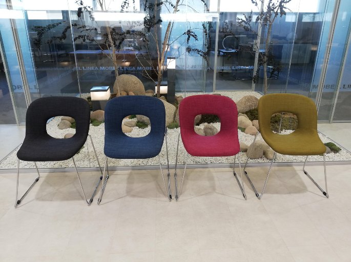 Assises coquille de couleurs vives alignées dans un hall vitré d'entreprise