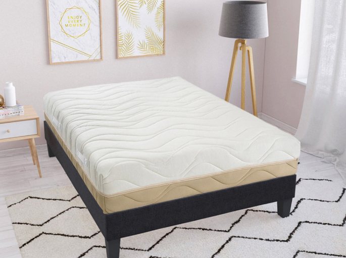 Chambre claire avec lit bas, linge blanc et petite table de chevet