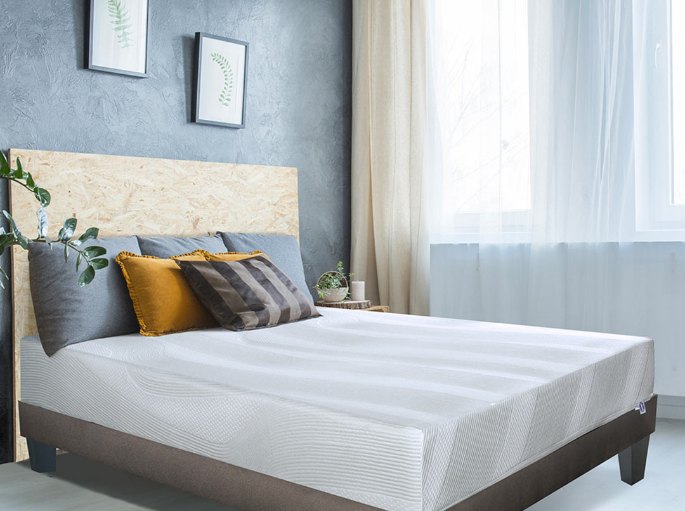 Couchage nu posé sur un cadre de lit dans une chambre aux murs bleus