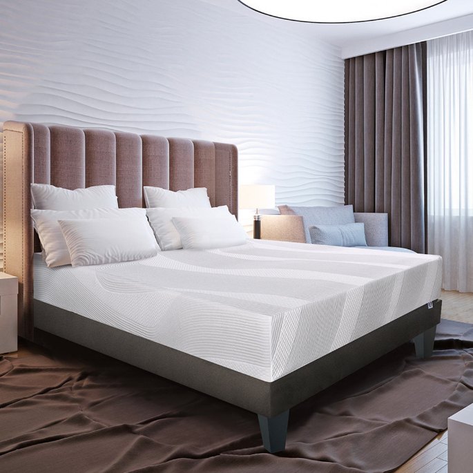 Couchage double habillé de linge clair dans une chambre d'hébergement touristique