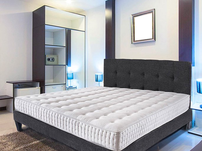 Chambre moderne équipée d’un lit bas et d’un couchage à coutil matelassé