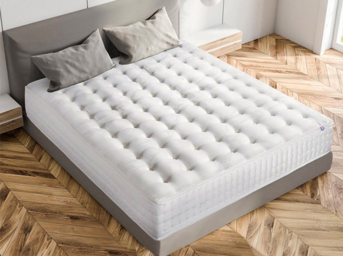 Coin nuit contemporain avec un couchage épais posé sur un parquet à chevrons