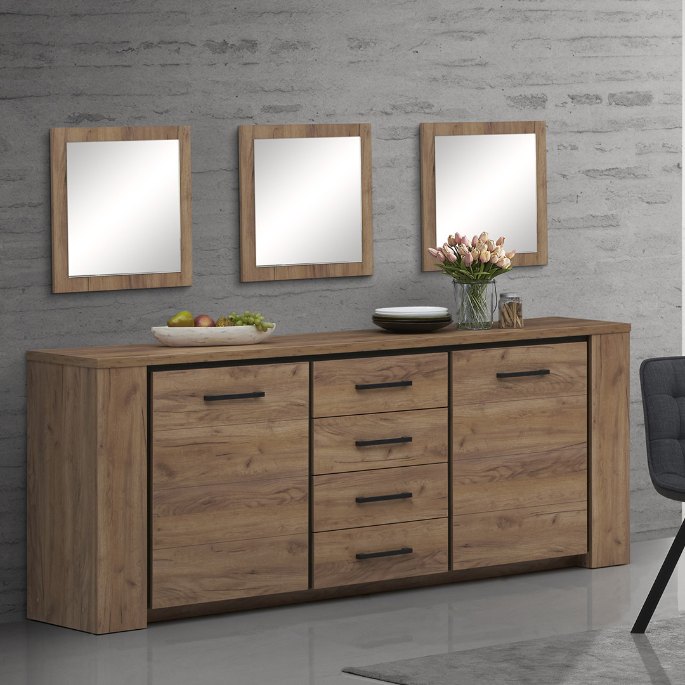 Trois cadres alignés au-dessus de la commode en bois clair