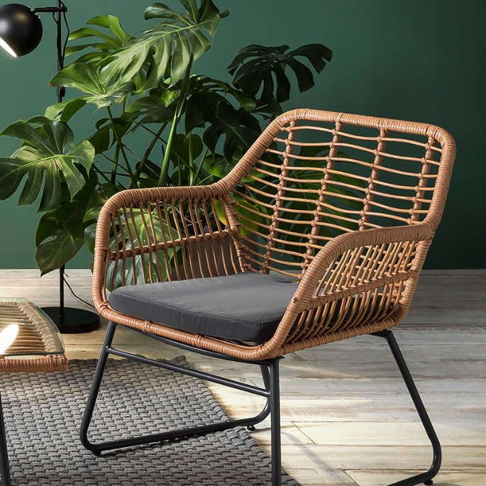Coin détente avec un fauteuil en fibre synthétique claire devant un mur végétalisé