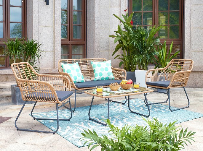 Coin détente sur une terrasse abritée avec canapé bas et tapis d’extérieur