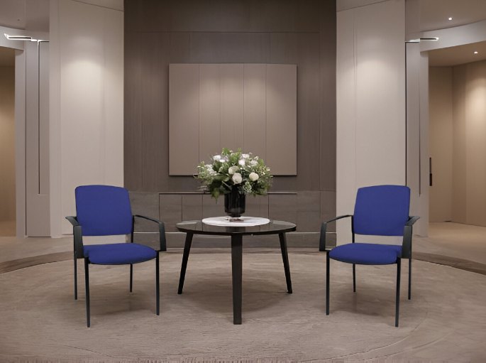 Espace d'attente aux tons chauds avec deux assises bleues et une table basse ronde