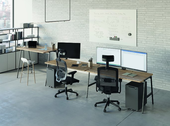Espace de travail partagé avec plusieurs postes équipés d'écrans et de fauteuils à roulettes