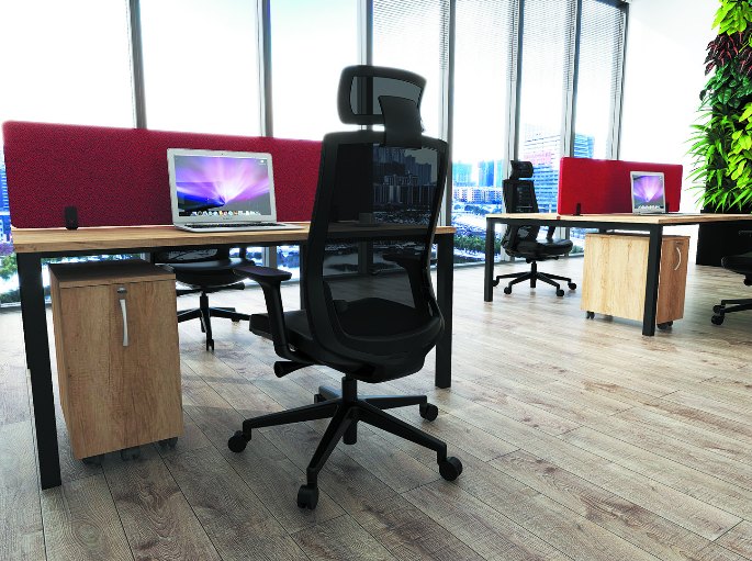 Poste de travail avec fauteuil à dossier haut et écran posé sur un plateau en bois clair