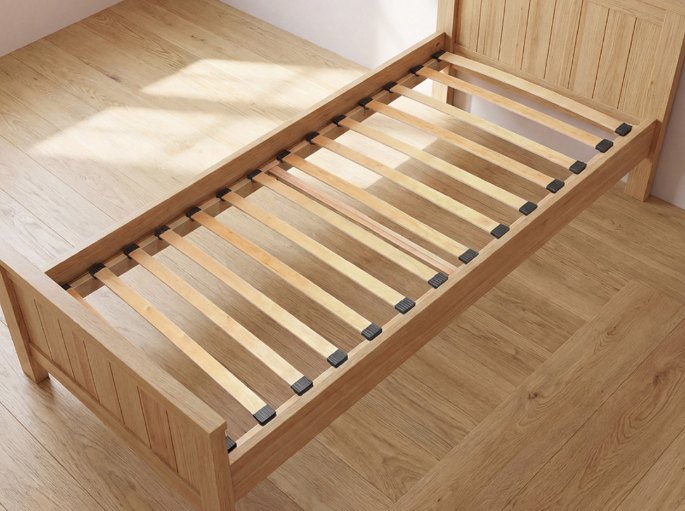 Structure de couchage en pin massif, traverses espacées visibles sous l'emplacement du matelas