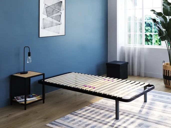 Couchage simple à traverses apparentes installé dans une chambre aux murs bleus