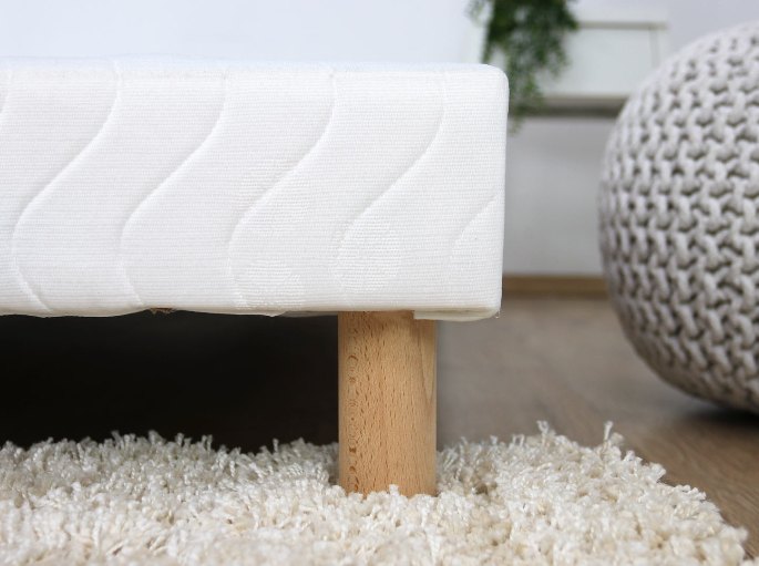 Coutil matelassé et pied bois vus de près sur un tapis à poils longs