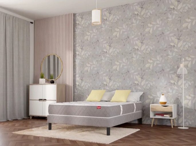 Pieds cylindriques relevant un plan de couchage à environ 55 cm du sol dans une chambre au papier peint fleuri