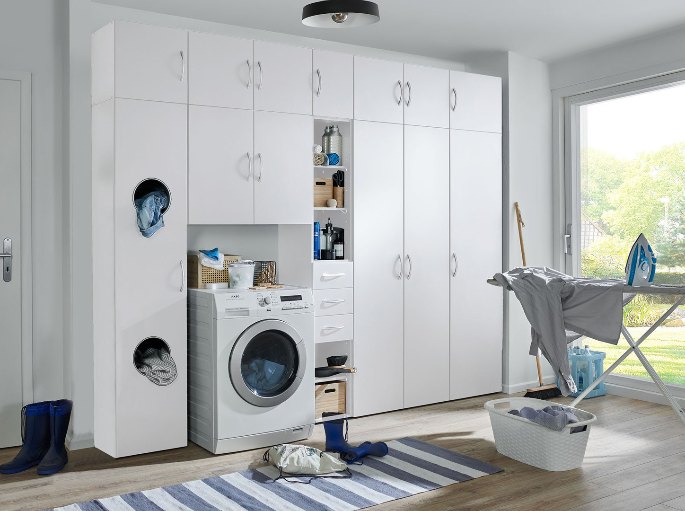 Coin lavage où l'appareil est glissé sous des placards hauts, planche à repasser à côté