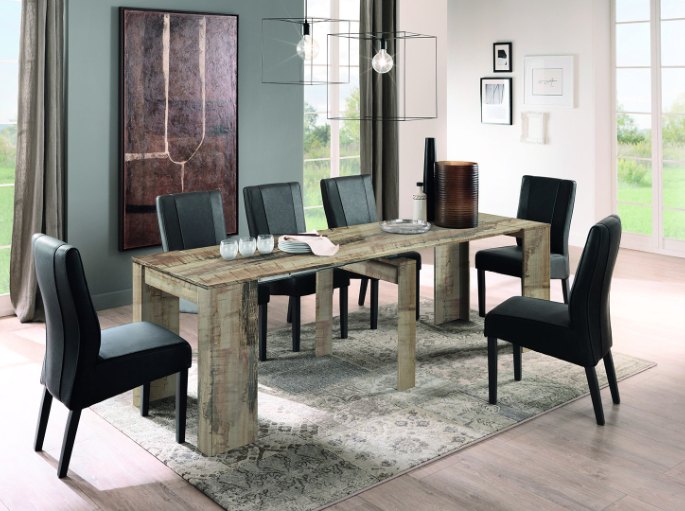Grande tablée en décor bois dressée pour huit convives près d’une fenêtre