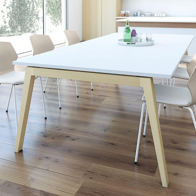 Grande table de réunion blanche sur piètement en bois clair entourée de chaises coque