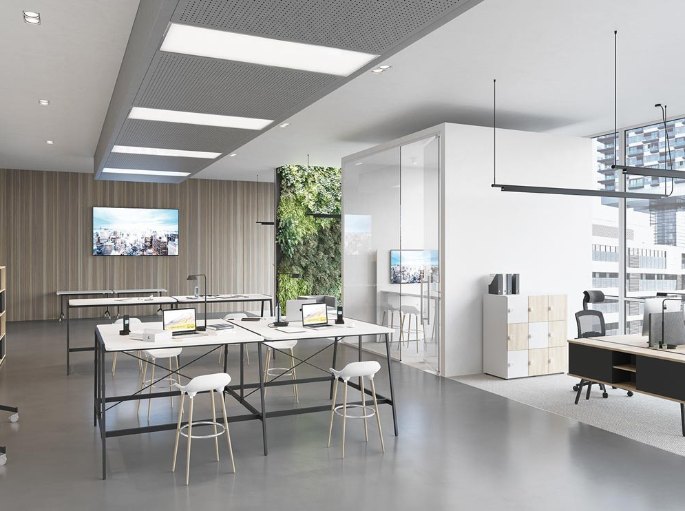 Îlot de réunion debout installé au cœur d'un plateau de bureaux avec écran mural