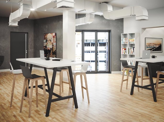 Plateau blanc sur piétement noir entouré de tabourets hauts dans un bureau aux murs gris