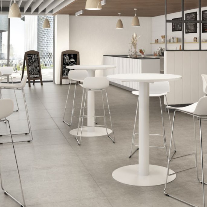 Coin café de bureau avec plusieurs plateaux hauts ronds blancs et tabourets
