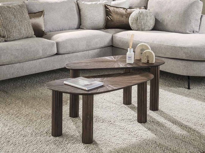 Plateaux triangulaires en bois foncé près d'un canapé d'angle beige