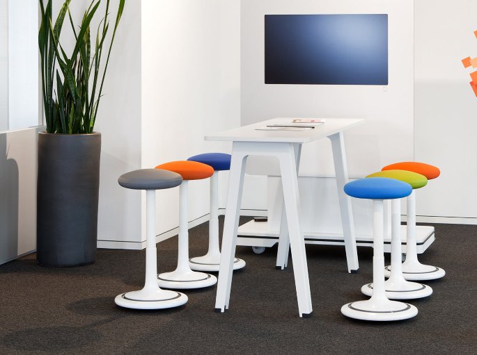 Coin d'échange équipé de tabourets réglables autour d'une table haute