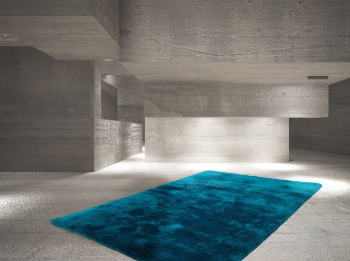 Grand rectangle bleu canard moelleux sur un sol en béton ciré