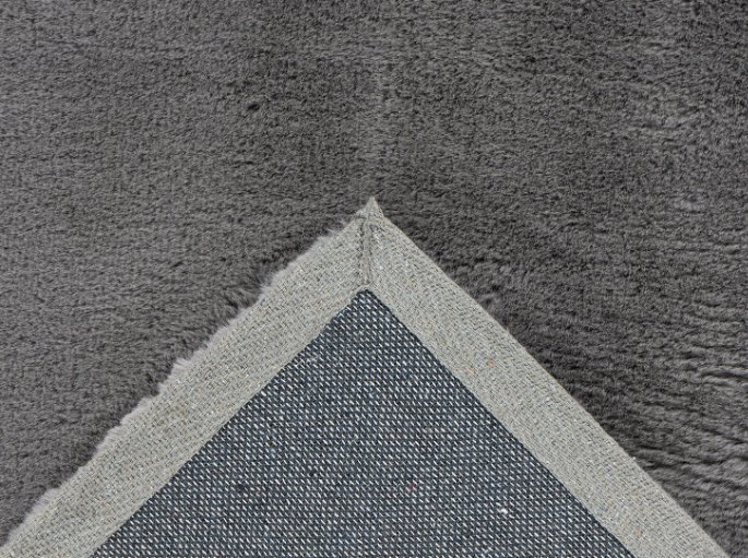 Coin retourné d'un velours gris laissant voir son dos tissé