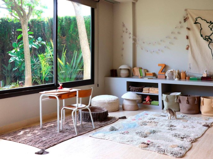 Chambre lumineuse avec un petit tapis en coton tissé posé sur le parquet